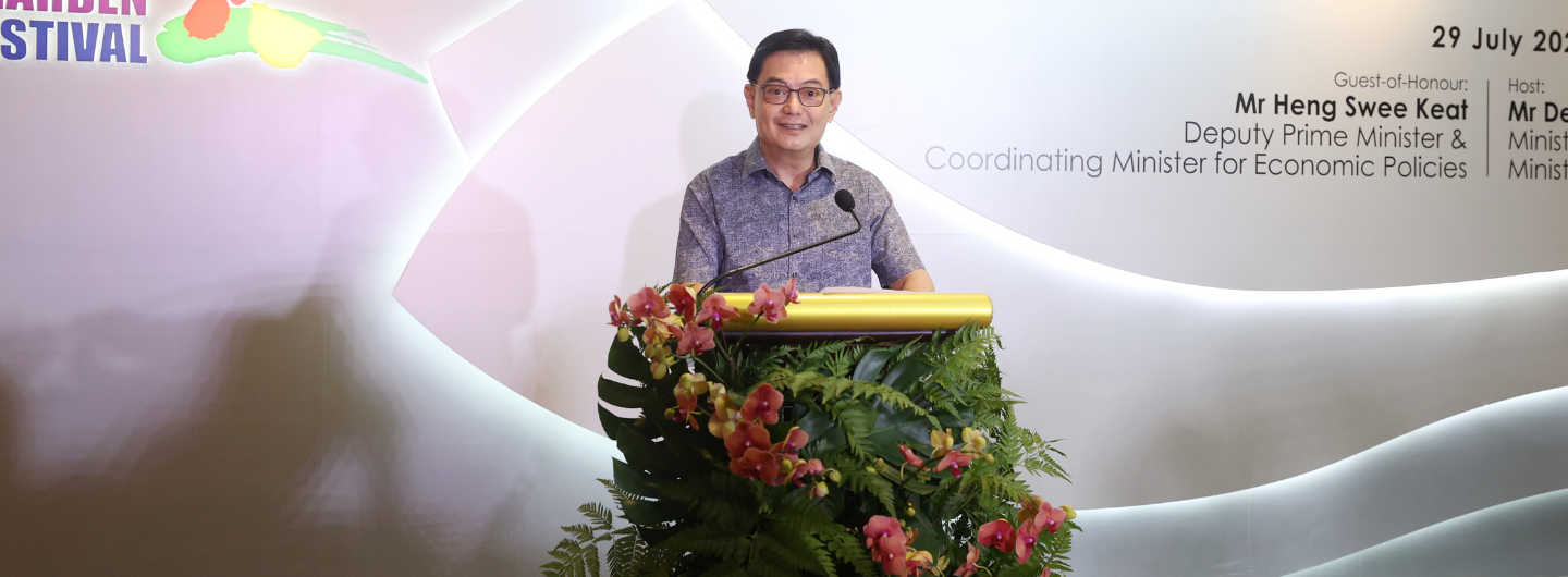 Heng Swee Keat at a podium decorated with orchids and ferns, speaking at the Garden Festival.